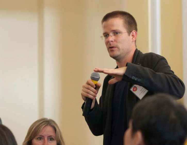 a man speaking into a microphone with a microphone in his hand