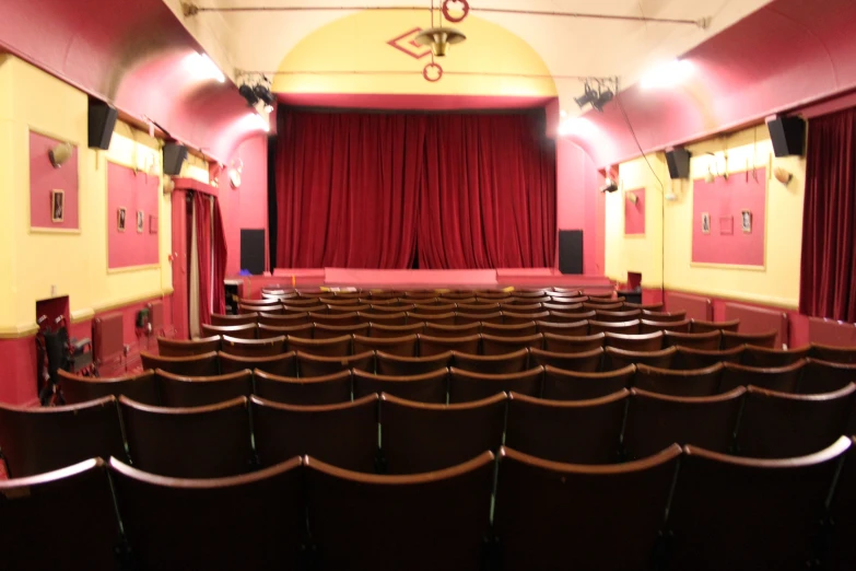 empty seats in the theater with red curtain