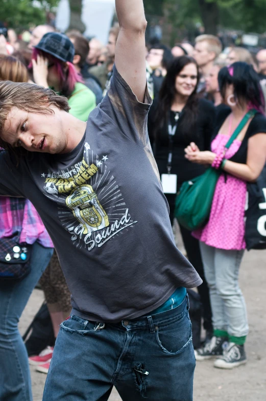 a man in jeans holding his hands in the air