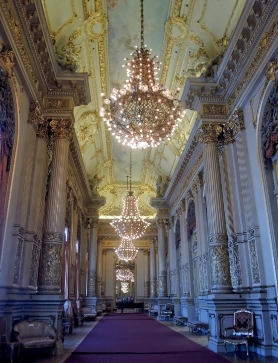 an old, fancy room with white walls and chandeliers