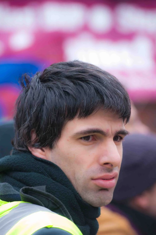 a close up of a person wearing a vest and black hair