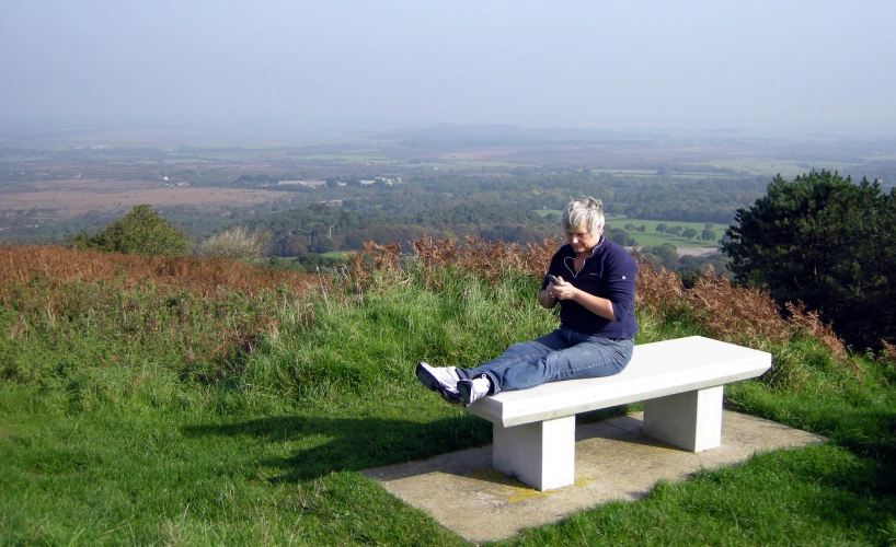 a man sitting on top of a white bench