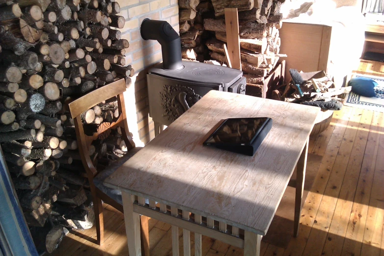 a table sits in front of the fireplace with several wooden logs