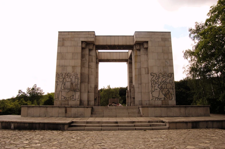 people stand in front of a cement monument