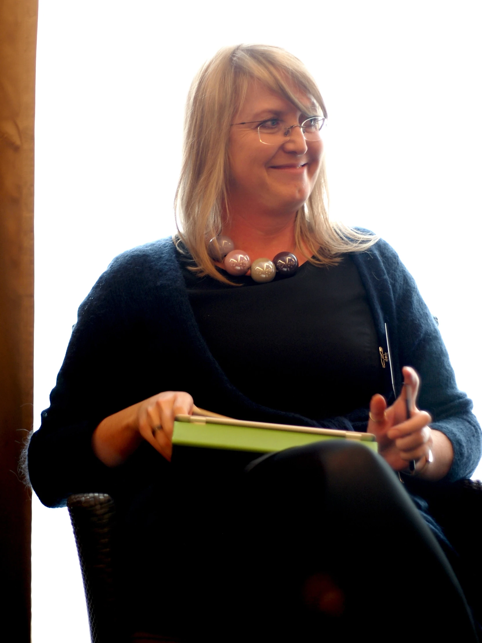 a woman wearing a black sweater is holding a binder and a book