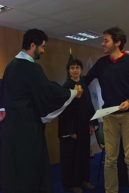 three people holding onto papers while standing next to each other