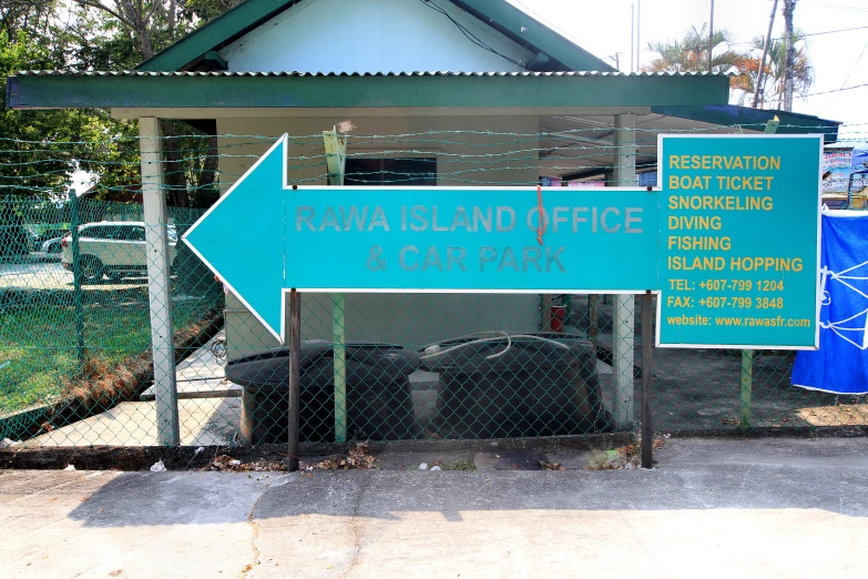 a blue sign pointing in the direction of torisha island office