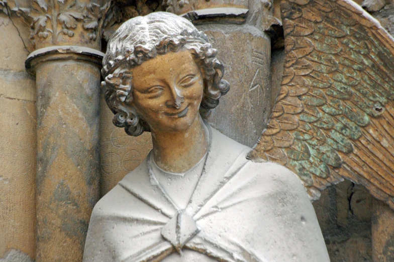 the head and shoulders of a statue of an angel with two outstretched arms