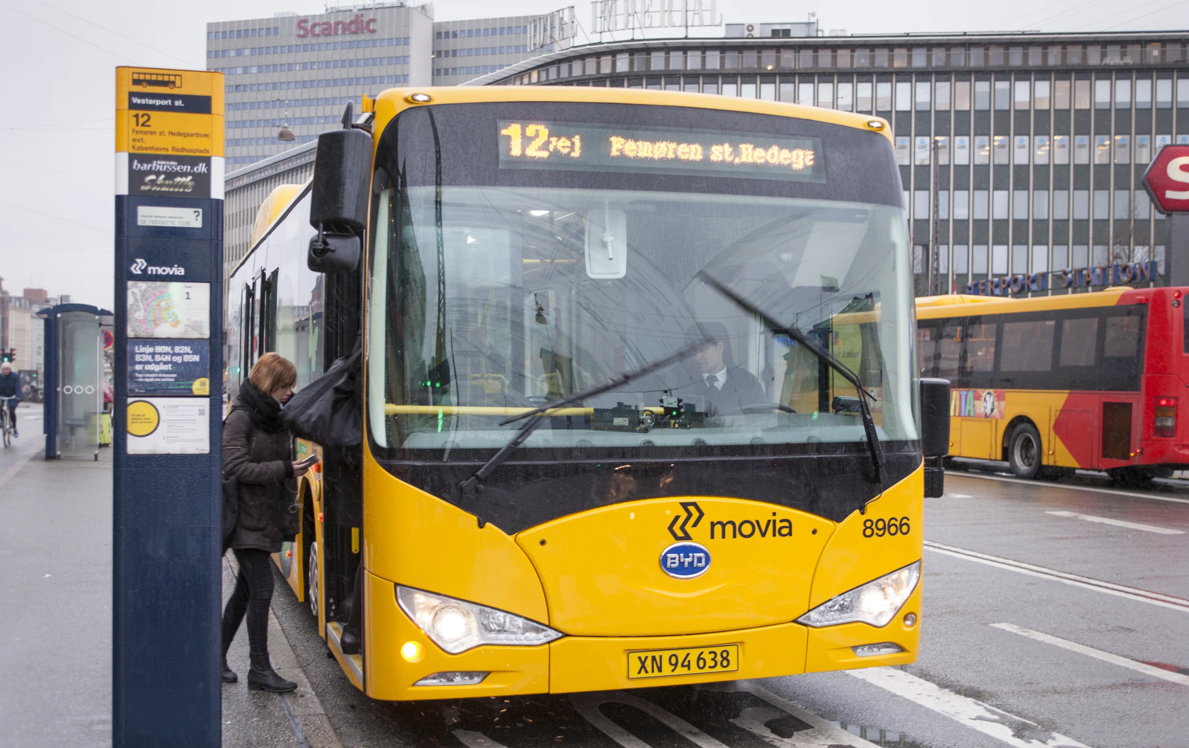 two people are getting on a yellow bus