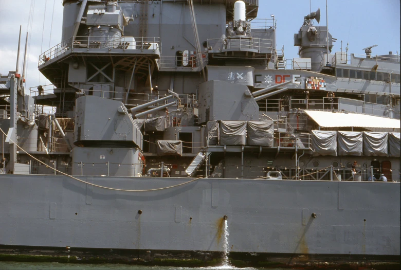 a large battleship sits alongside a body of water