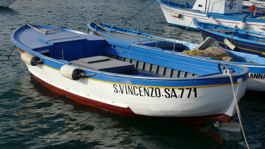 several boats docked together with ropes hanging off the front