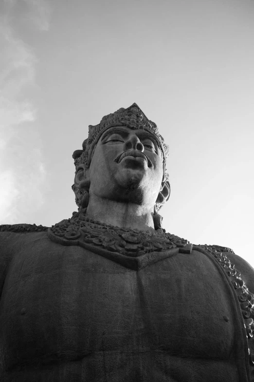 the large statue is standing in front of a clear sky