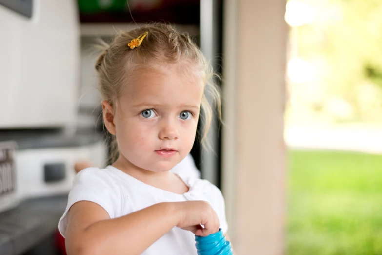 a little girl holds a towel and looks directly at the camera