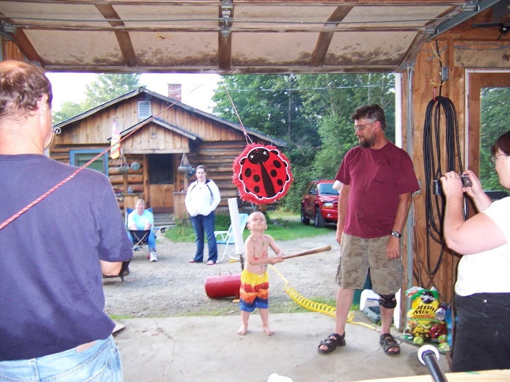 people are holding fire hoses and watching an individual play with a fire hydrant