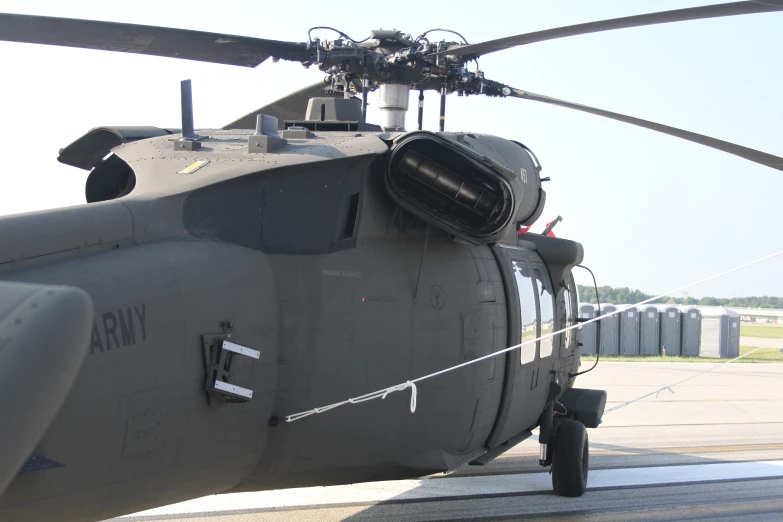 a black army helicopter sits on the tarmac