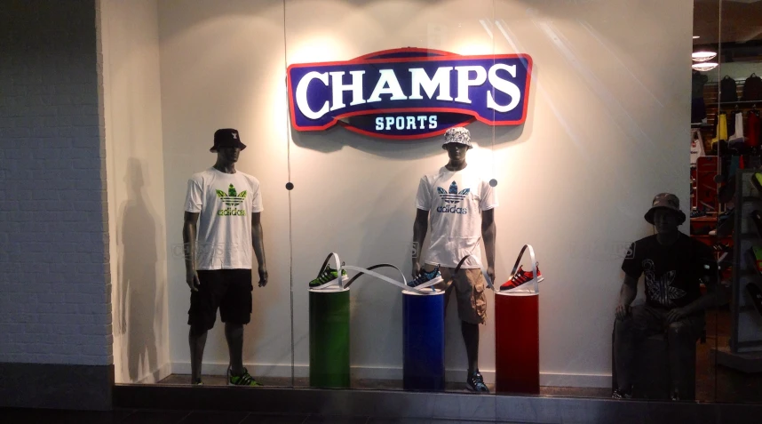 three mannequins in front of a store sign with lights on