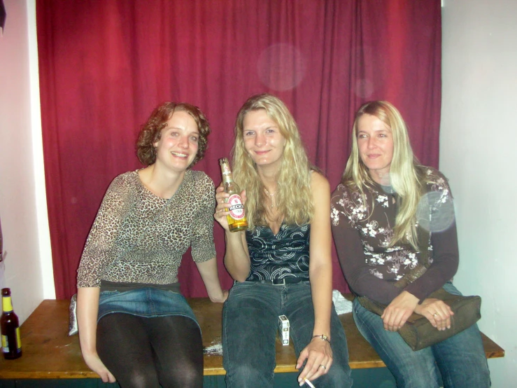 three people sitting next to each other on a table