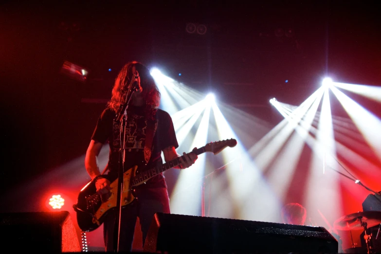 a man playing guitar with two other people