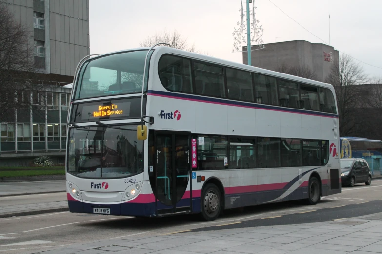 a white double decker bus driving down a street