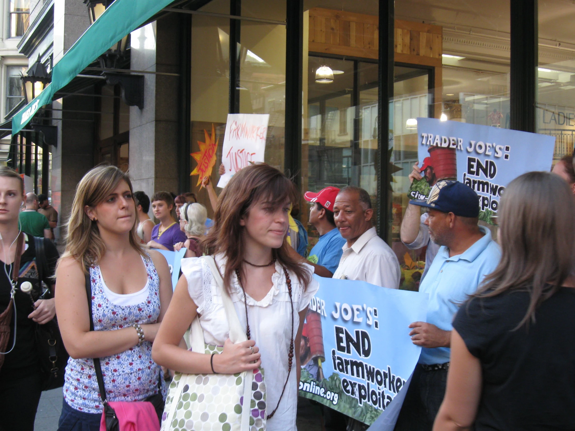 two young ladies holding up signs in the crowd