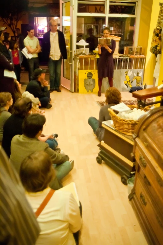 people are gathered around a room where wooden boxes are holding objects