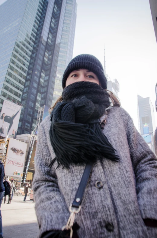 a woman standing next to a tall building