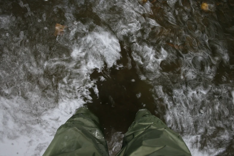 the feet of a persons in snow shoes are reflected in water