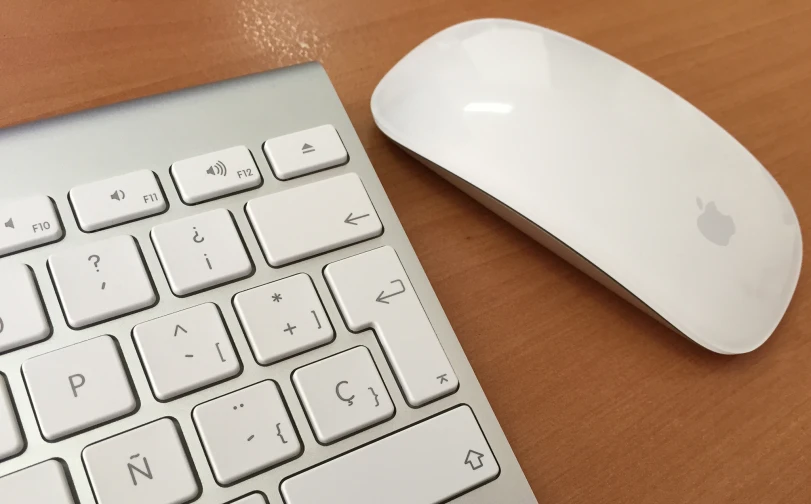 an apple mouse next to a wireless keyboard