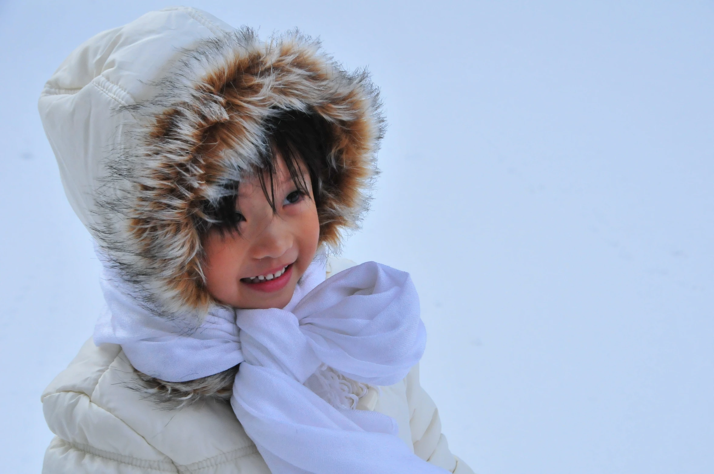 a  in the snow wearing a jacket and scarf