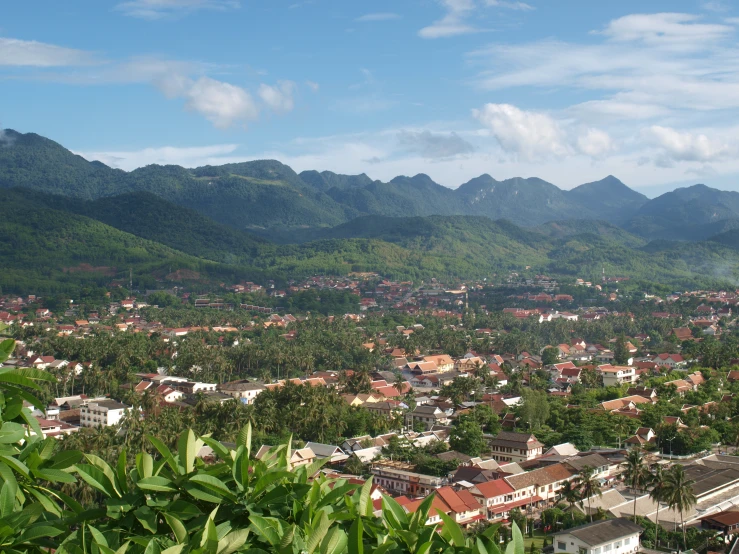 aerial view of city surrounded by green mountains