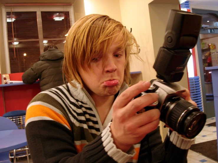 a man taking a po with his camera and making a weird face