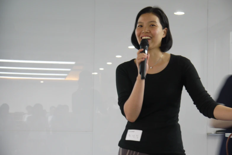 a woman stands in front of the microphone