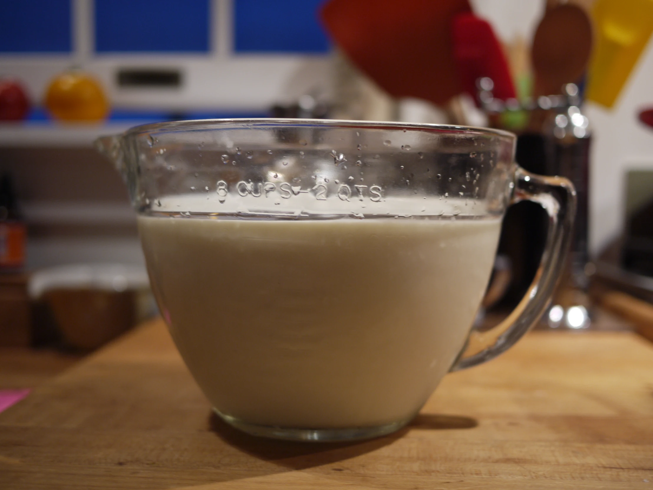 a glass pitcher full of milk and sugar sitting on a table