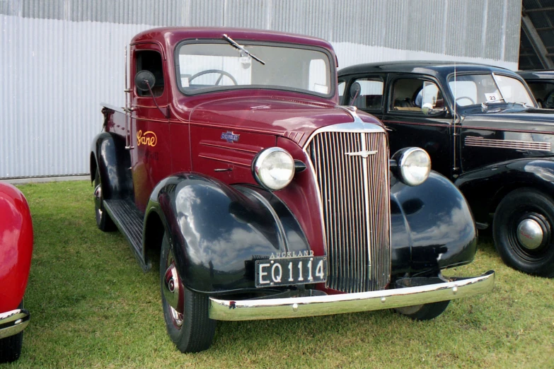 two old time cars are parked on the grass