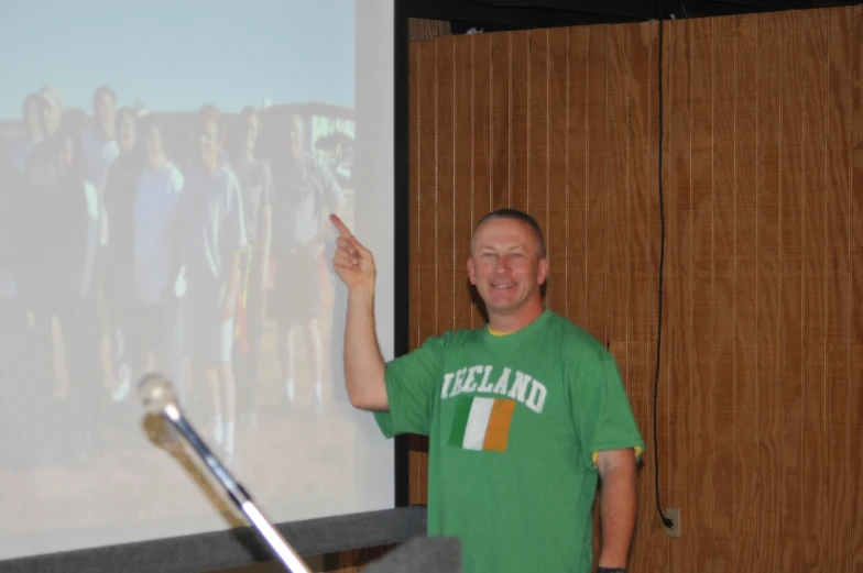 the man is giving a presentation on a large screen