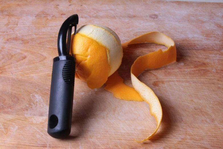 a peeled orange sitting on top of a wooden  board