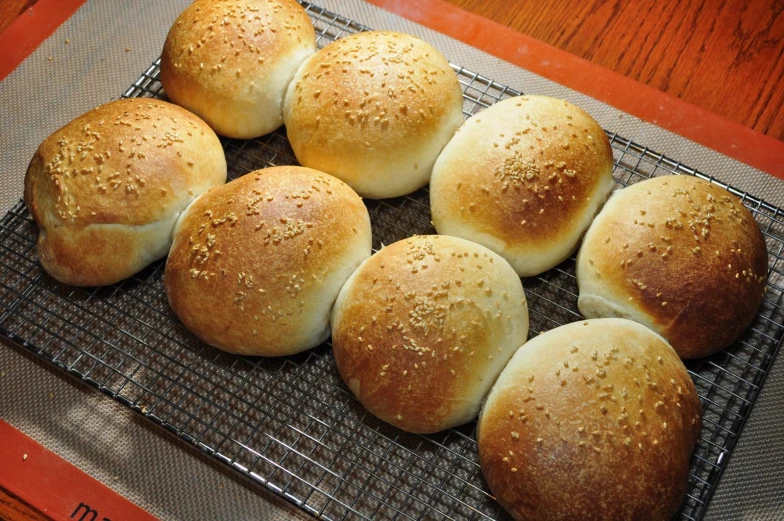 six rolls on a cooling rack on top of a table