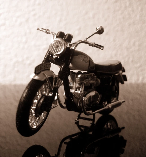 a small black and white motor bike in the spotlight