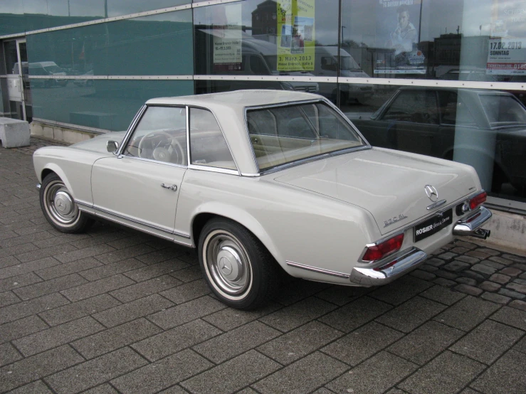 an old classic car is parked next to the building