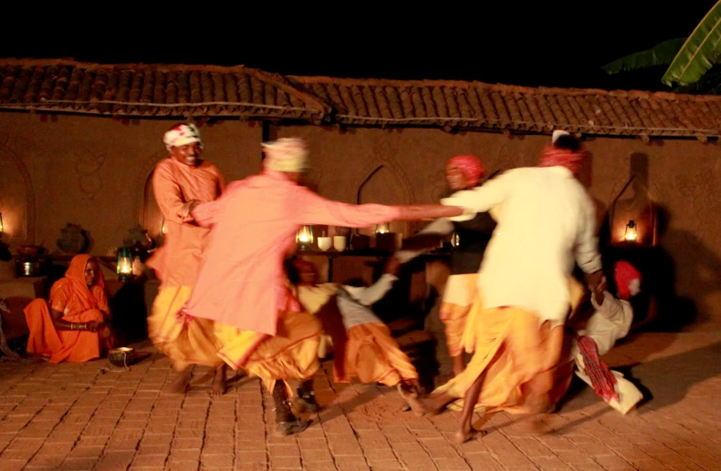 men in orange and yellow performing a musical