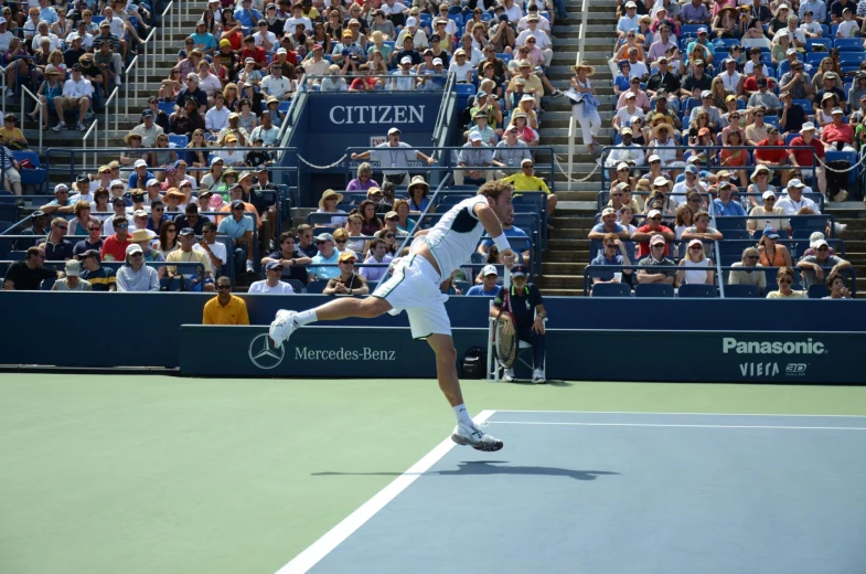 a man holding a tennis racket standing on a tennis court