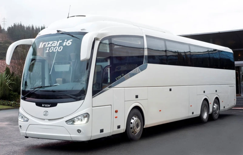 a large white bus parked in front of a building