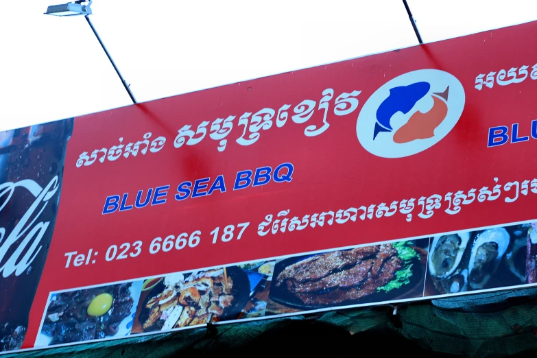 a red sign advertising some sea bbq food and drink