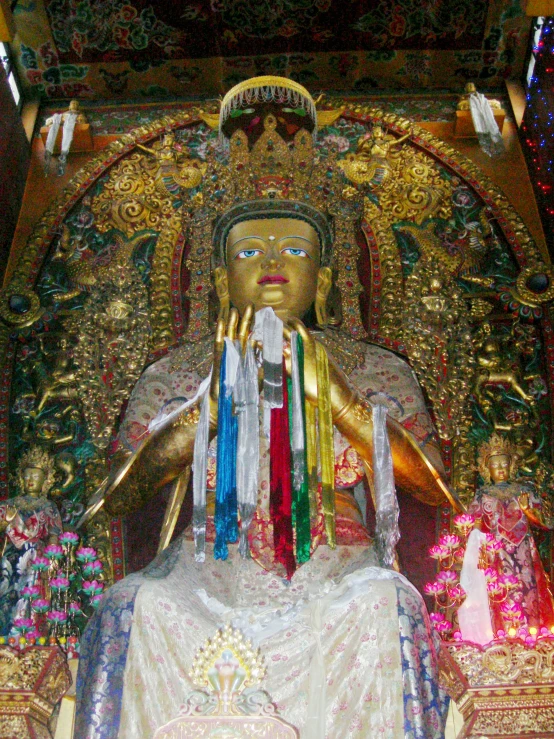 a gold statue sitting on top of a large white statue