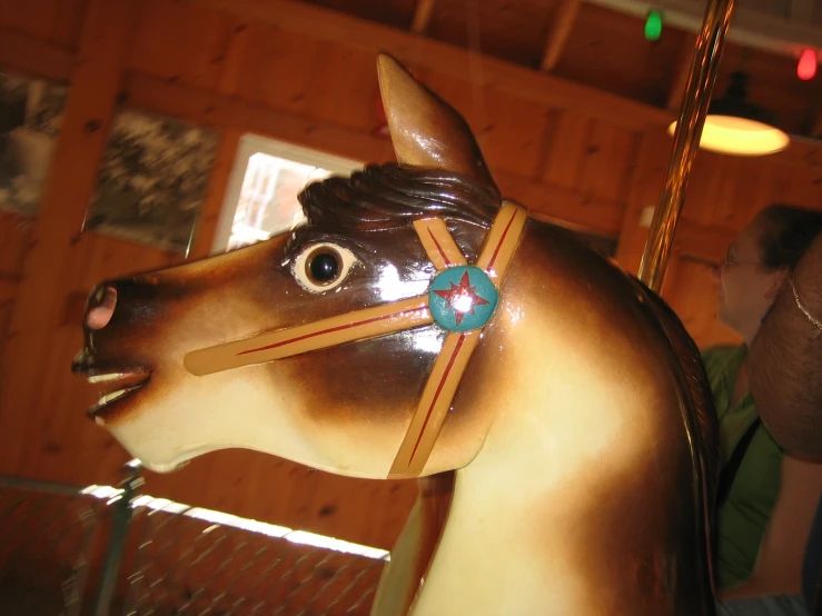 a wooden carousel horse that is in a show room