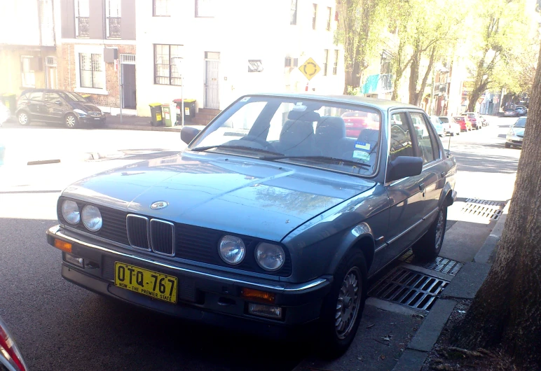 a bmw eife is parked next to a curb