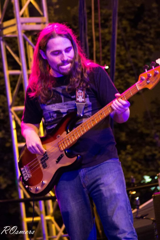 a man playing a guitar with a microphone in the background