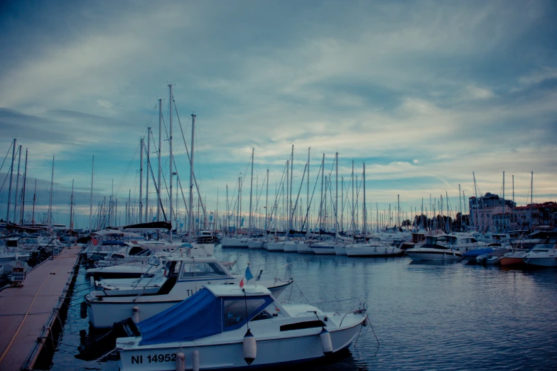 a small marina with sailboats and yachts on a lake