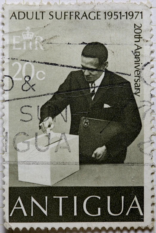 a postage stamp on a man putting his shoes inside a shoe box