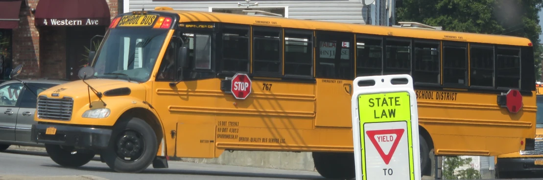 the school bus is parked next to a sign